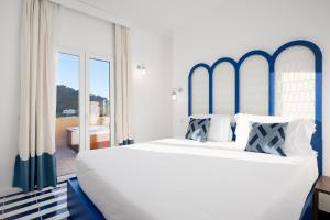 a bedroom with a large white bed with blue accents at Villa Lia Hotel Capri in Capri +70 photos