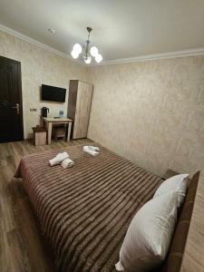 a bedroom with a large bed with two towels on it at Rifah Hotel in Qusar