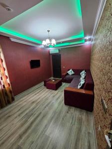 a living room with a couch and a tv at Rifah Hotel in Qusar