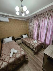 a hotel room with two beds with towels on them at Rifah Hotel in Qusar