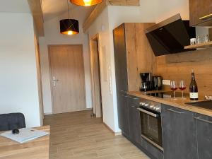 a kitchen with a stove and a counter with wine glasses at Apartment Turmfalke in Vogtsburg