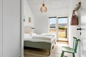 a bedroom with a bed and a chair and a window at LN1842-Hjorring-Lobet-5 in Hjørring