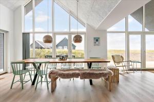 a dining room with a table and chairs and windows at LN1842-Hjorring-Lobet-5 in Hjørring