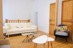 a living room with a white couch and two chairs at VILLA treize quartier balnéaire in Mers-les-Bains