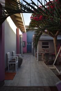 a patio with a table and chairs and a tree at La Flamingo Guesthouse in Walvis Bay