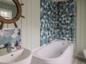 a bathroom with a tub and a sink and a mirror at 5B Bridge Street in Lyme Regis +27 photos