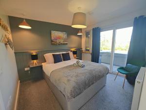 a bedroom with a bed with blue walls and a window at Jack's Hideaway in Gatehouse of Fleet