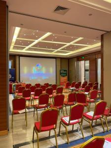 a conference room with chairs and a projection screen at Gloria Hotel in Polana Caniço "A"