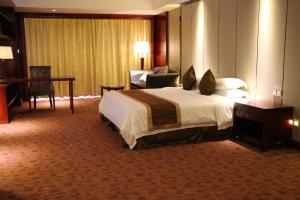 a hotel room with a bed and a desk and a chair at Gloria Hotel in Polana Caniço "A"