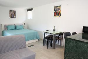 a room with a bed and a table and a bed and a table and chairs at Retiro Maria Idalina in Amarante