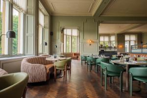 a dining room with tables and chairs and windows at Apex Dunblane Hydro in Dunblane