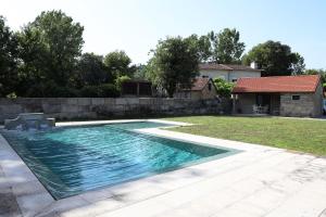 a swimming pool in a yard with a stone wall at Retiro Maria Idalina in Amarante +12 photos