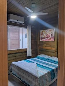 a bedroom with a bed in a wooden room at Chalés Lar Doce Mar in Jaguaruna