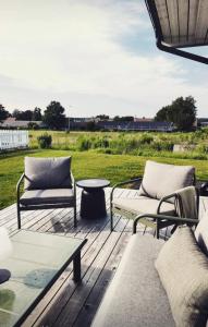 a patio with two couches and a table at Vila Karup Modern Scandinavian Holiday Home in Båstad