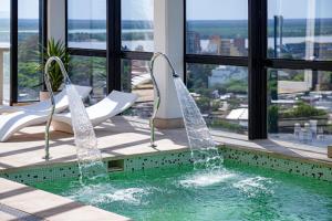 a pool in a building with chairs and water at Mercure Rosario in Rosario