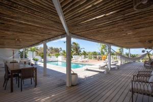 a wooden deck with a table and chairs and a pool at Villa Tomama by Preabeach Experience in Prea