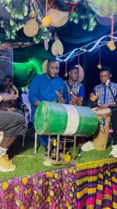 a group of people sitting around a table with a barrel at Lexworld Hotels in Aba