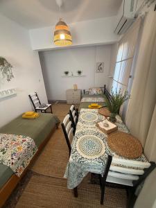 a room with two beds and a table and chairs at Azure & Zest Suites in Ierissos