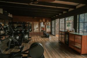 a gym with exercise equipment in a room with windows at Saseka Tented Camp in Hoedspruit