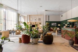 a lobby filled with lots of potted plants at COVE Centrum in The Hague +7 photos