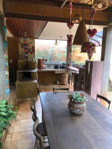 a kitchen with a long wooden table and a kitchen with a counter at Zíngara - Kombi Home in Brumadinho
