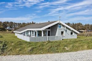 a white house sitting on top of a grass field at LN1791-Hjorring-Hongardsvej-1 in Hjørring