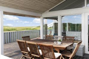 a porch with a wooden table and chairs at LN1791-Hjorring-Hongardsvej-1 in Hjørring