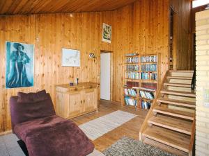 a living room with wooden walls and a wooden staircase at 8 person holiday home in Asnæs in Asnæs