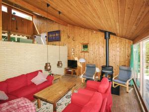 a living room with red couches and a fireplace at 8 person holiday home in Asnæs in Asnæs