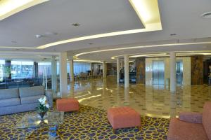 a lobby with a couch and chairs in a building at Falls Iguazú Hotel in Puerto Iguazú +65 photos
