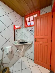 a bathroom with a sink and a red door at Pousada Mirante das Fitas in Arraial d'Ajuda +55 photos