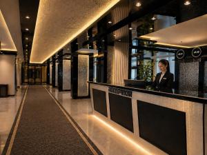 a woman standing at a counter in a building at EMİRGAN Otel in Bağlık