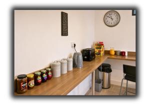 a kitchen with a counter top with jars and a clock at Kop View Rooms in Liverpool