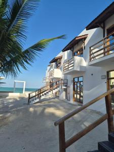 a building on the beach with a palm tree at Jambo Resort by Mambo Hotels in Paje