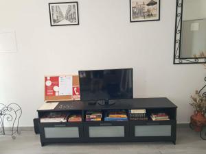 a black entertainment center with a flat screen tv on top at Refúgio Viçoso in Vila Viçosa