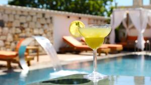 a drink sitting on a table next to a swimming pool at Canata Çeşme in Çeşme