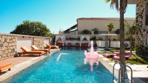 a swimming pool with pink inflatable flamingos in the water at Canata Çeşme in Çeşme