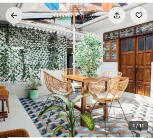 a dining room with a table and chairs and a plant at The courtyard Zanzibar in Ngambo
