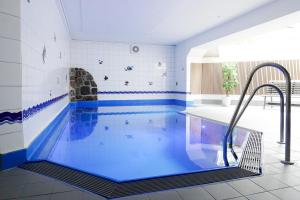 a swimming pool with blue water in a room at TRA7c Ferienwohnung Kossmann in Niendorf