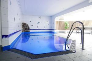 a swimming pool with blue water in a room at TRA7 "Residenz Windrose" - App Reichelt in Niendorf