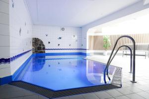 a swimming pool with blue water in a room at TRA7d Ferienwohnung Kossmann in Niendorf