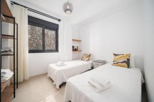 two beds in a white room with a window at My house in Kaş in Kaş