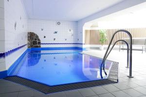 a swimming pool with blue water in a building at TRA7b "Residenz Windrose" in Niendorf