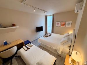 a hotel room with two beds and a desk and a table at Verónica's Flat Playa Paraíso in Playa Paraiso
