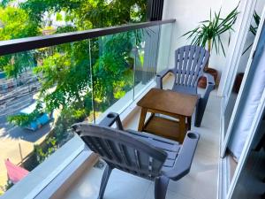 a balcony with two chairs and a table at Yuhum Boracay Suites in Boracay