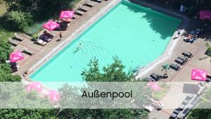 an overhead view of a swimming pool with pink umbrellas at Apartment Ostseeblick 131 in Timmendorfer Strand