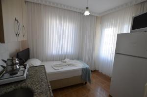 a hotel room with a bed and a refrigerator at Cane Motel in Avşa Adası