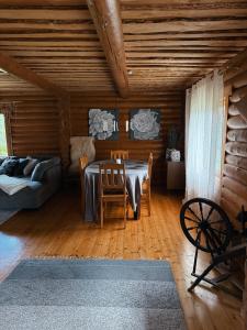 a dining room with a table and chairs and a couch at Hubane palkmaja Otepää südames in Otepää