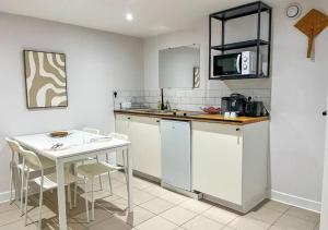 a kitchen with a counter and a table and a microwave at Doux Pavillon - Sauna - Jacuzzi in Tassin-la-Demi-Lune
