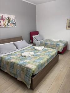 two beds in a room with towels on them at La casa di Gio' Lake Maggiore Near Leonardo in Dormelletto